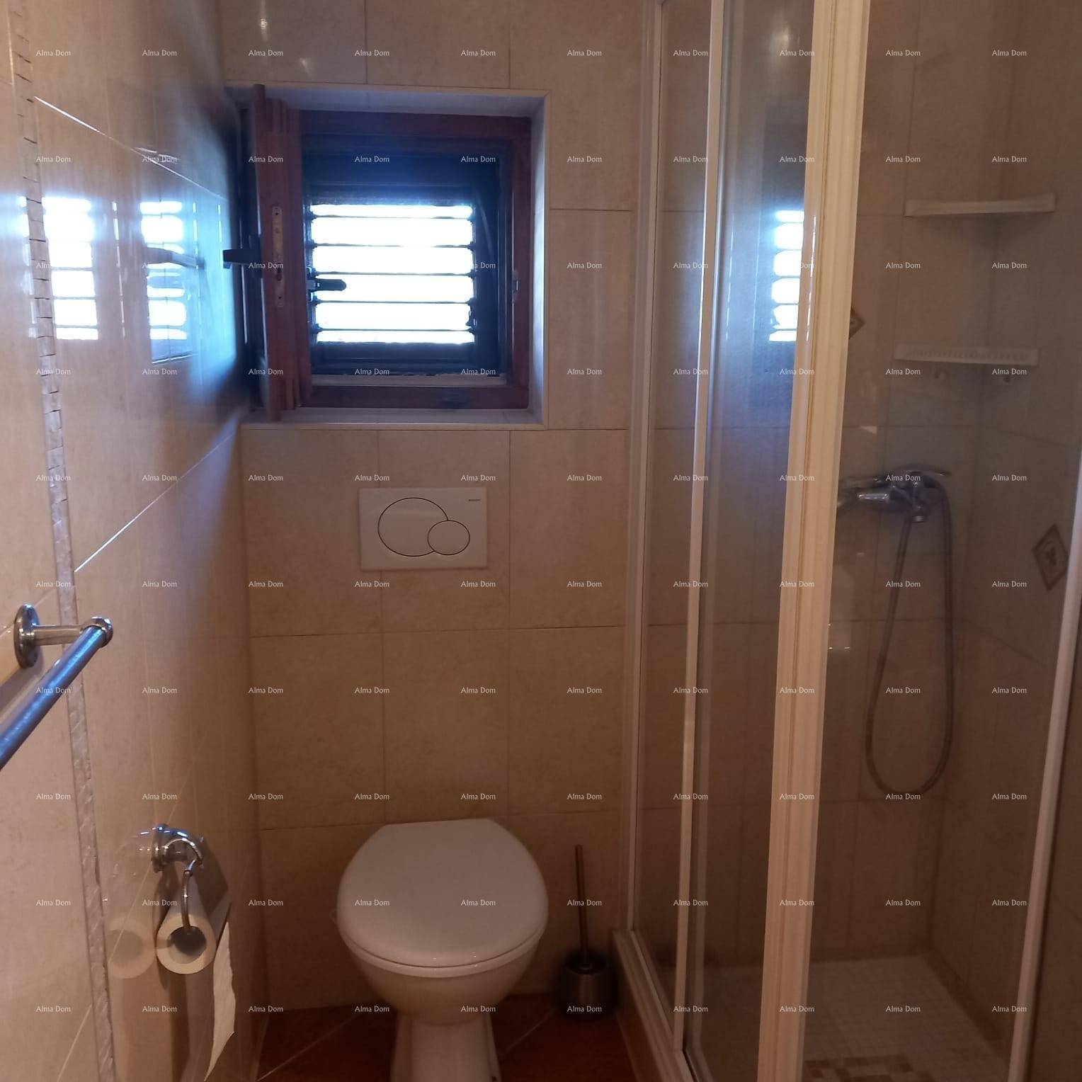 Badezimmer mit Toilette, Duschkabine und Fenster für natürliche Belüftung.
