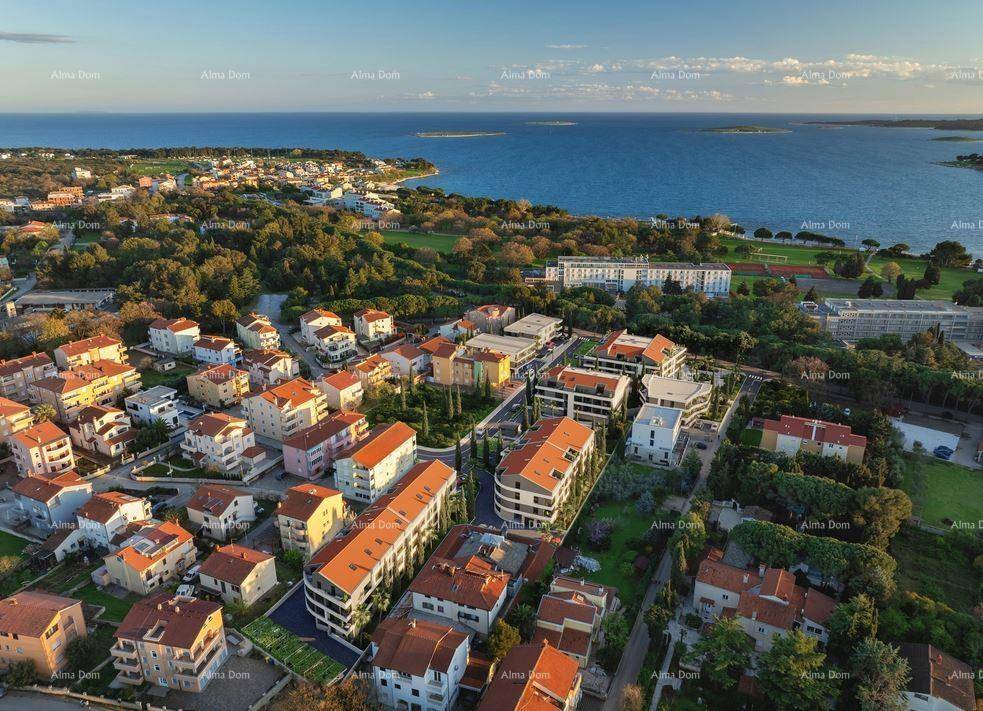 Weitläufige Luftaufnahme der modernen Wohnanlage mit Meerblick und umliegender Stadtlandschaft.