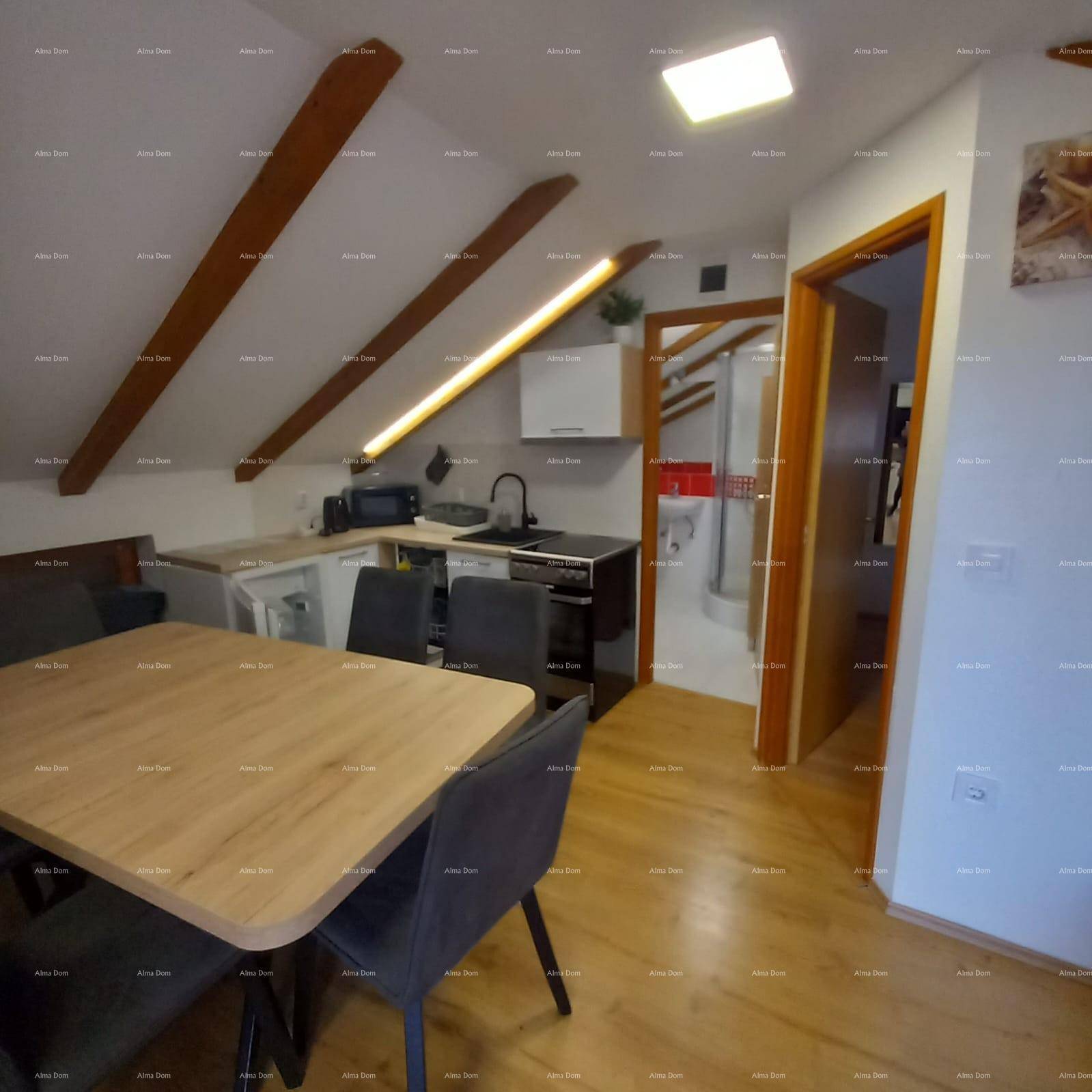 Moderne Küche mit Essbereich unter Dachschrägen und Blick ins Badezimmer.