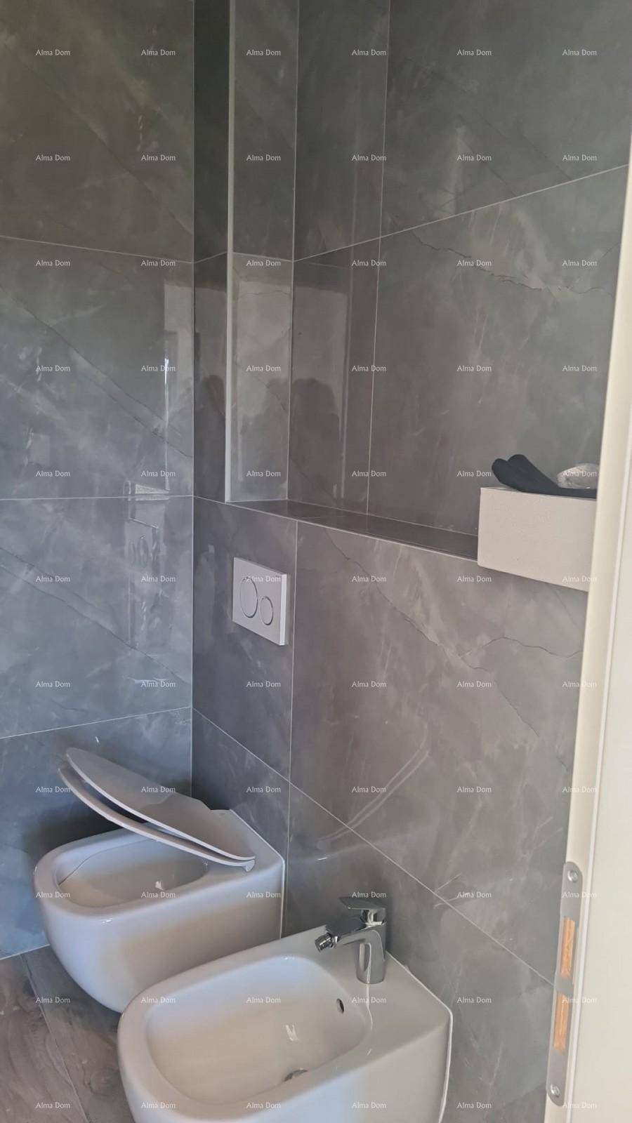 Modernes Badezimmer mit grauen Fliesen, wandhängendem WC und Bidet.