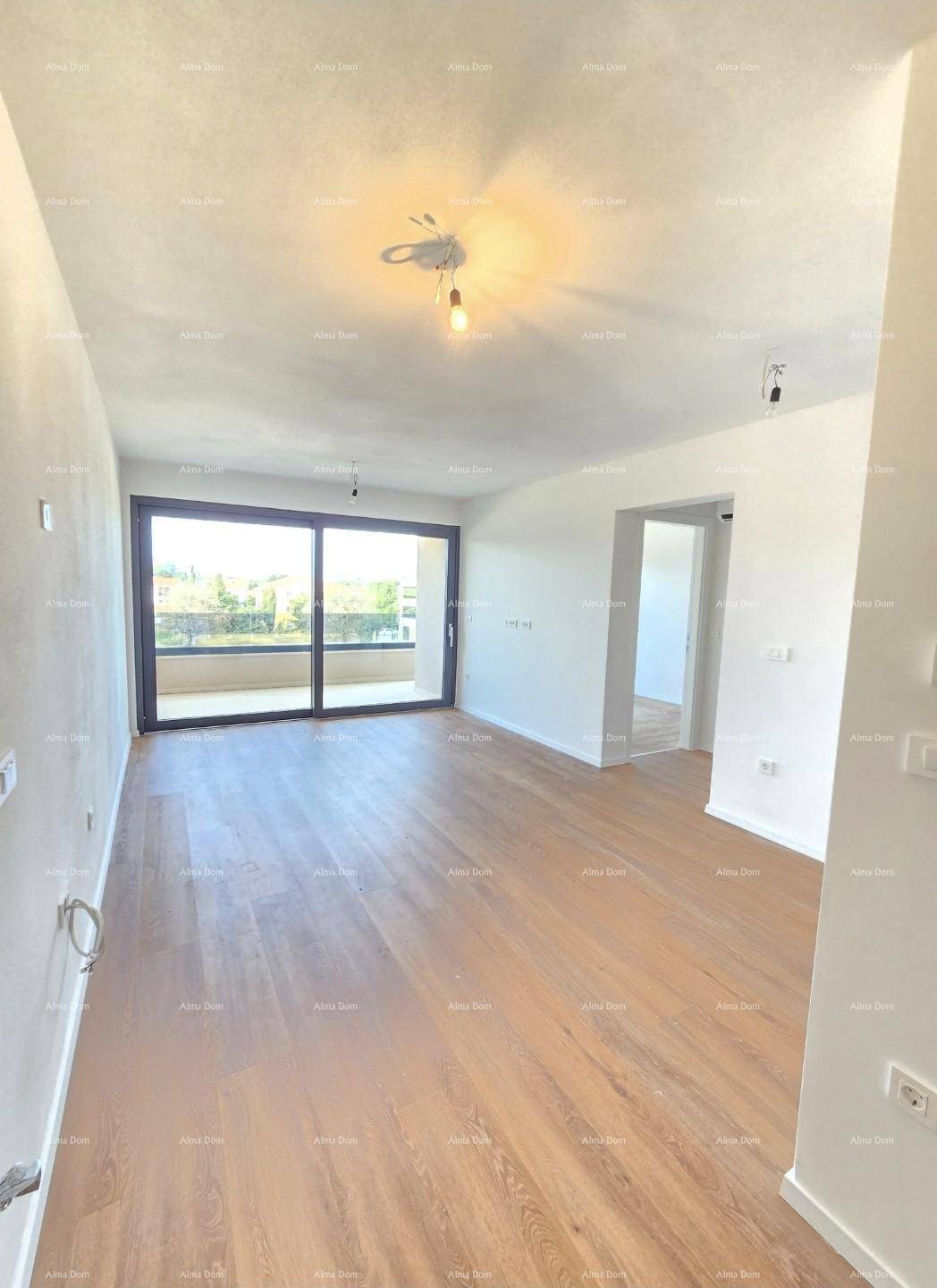Heller, leerer Wohnraum mit Holzboden und großen Schiebetüren zum Balkon.