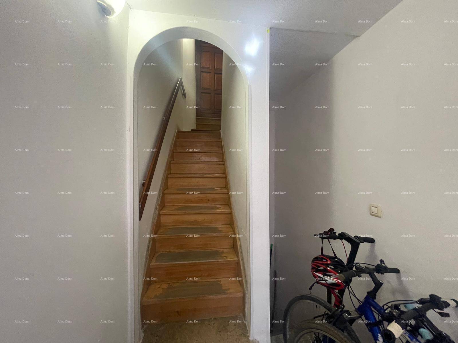 Treppenhaus mit Holzstufen und Bogen, daneben ein Fahrrad abgestellt.