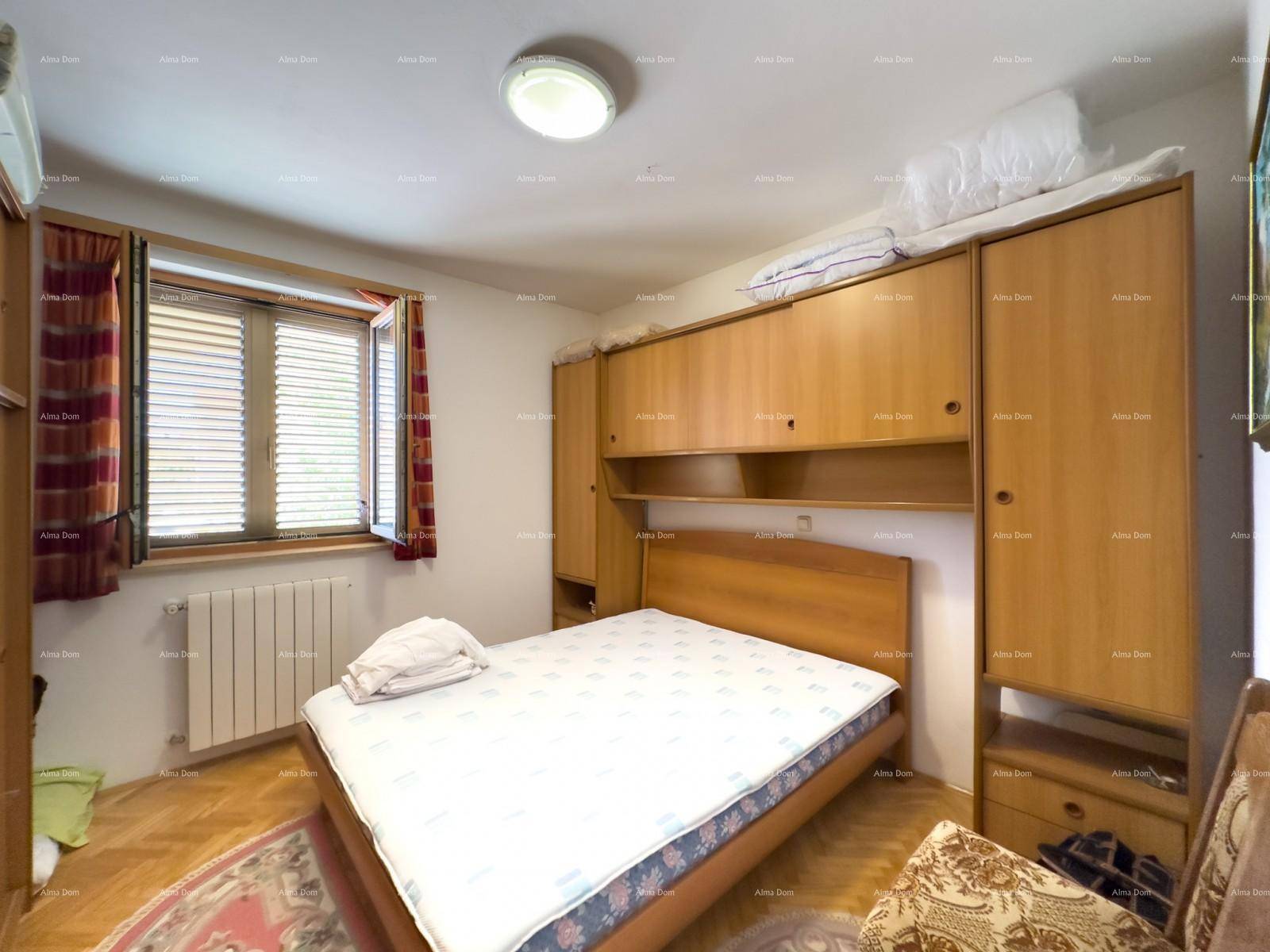 Schlafzimmer mit Einzelbett, Einbauschränken und Fenster mit Jalousien.