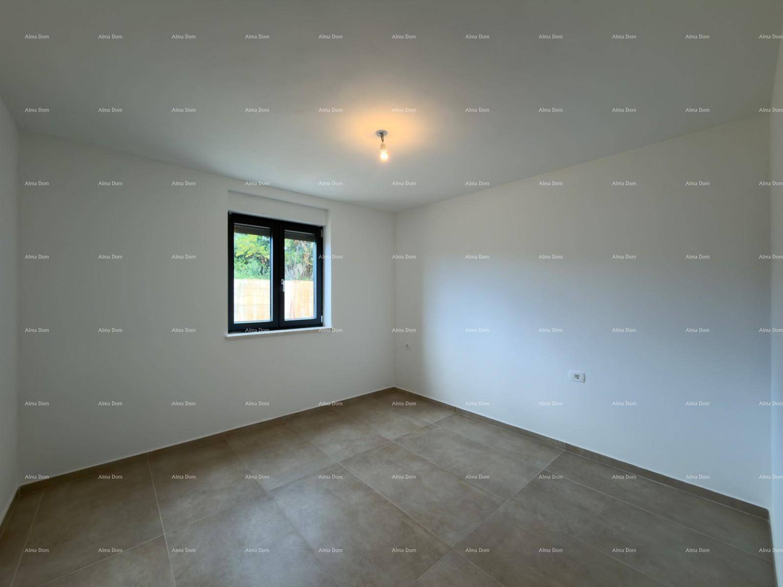 Leeres Schlafzimmer mit hellen Wänden, Fliesenboden und einem modernen Fenster mit Ausblick ins Grüne.