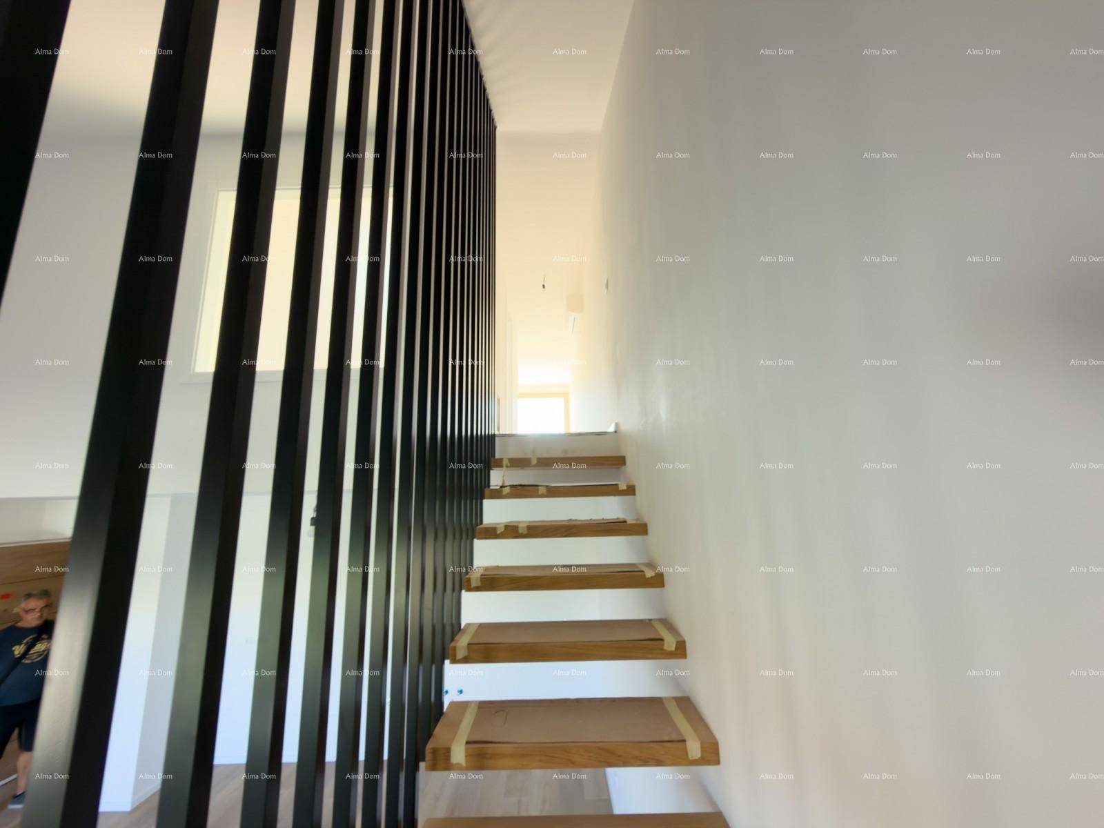 Moderne Holztreppe mit schwarzem Geländer, die die Etagen des Hauses verbindet.