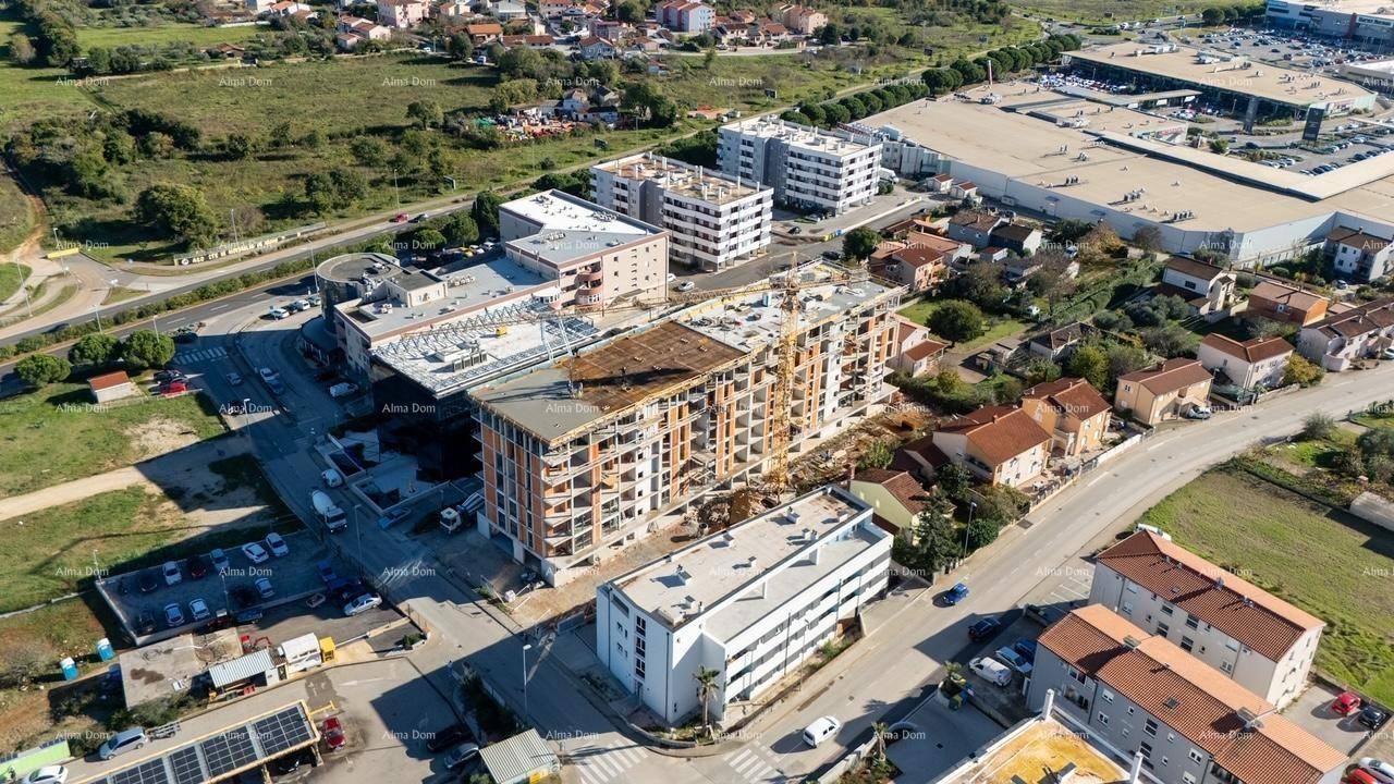 Luftaufnahme eines Stadtteils mit einer Baustelle, umgeben von Wohn- und Gewerbegebäuden.