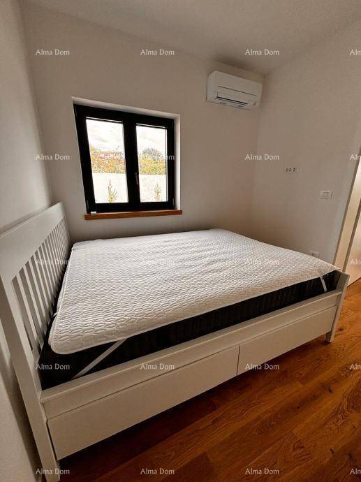 Helles Schlafzimmer mit Holzboden, weißem Bett und Klimaanlage an der Wand.