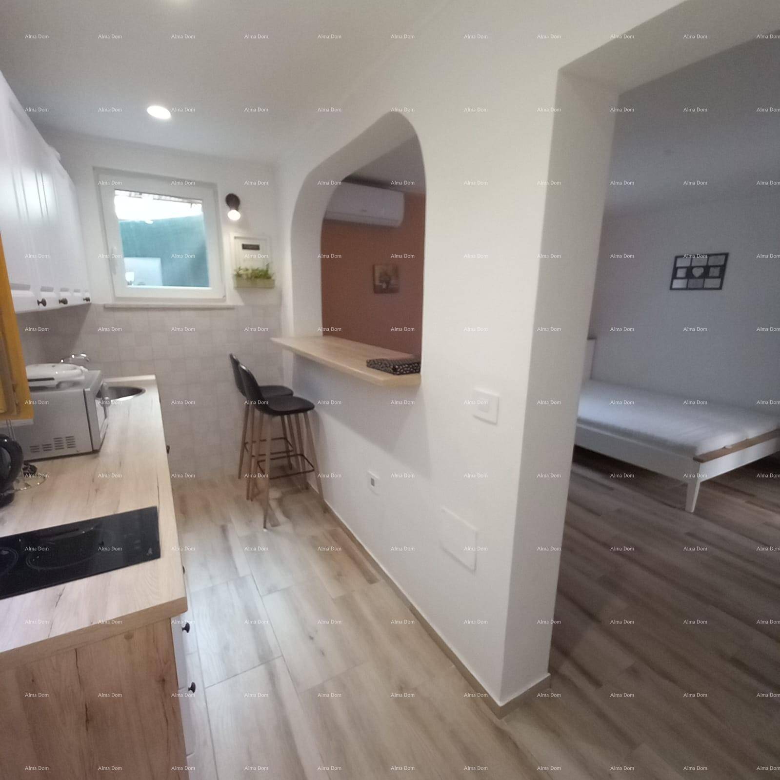 Moderne Küche mit Holzarbeitsplatte und Frühstücksbar, offen zum Schlafbereich.