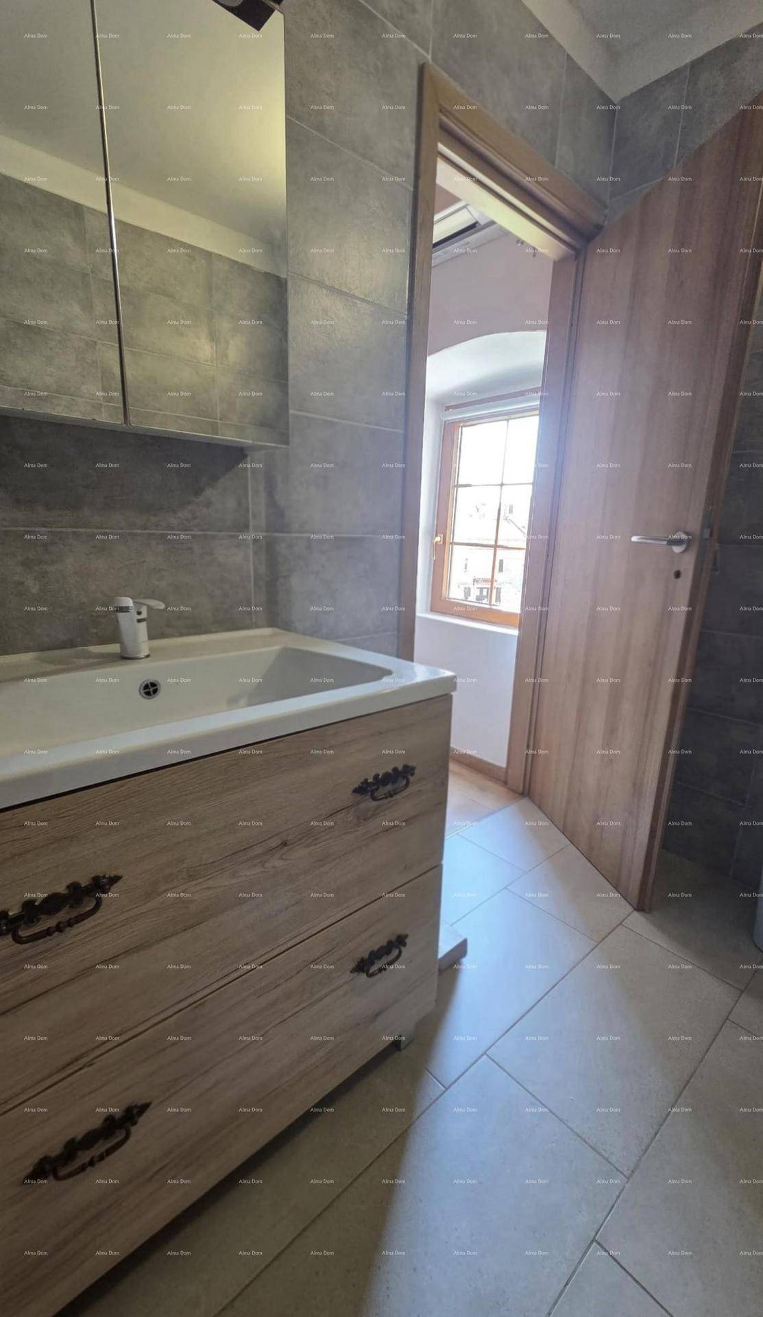 Modernes Badezimmer mit Holzwaschtisch, grauen Fliesen und Fenster für natürliches Licht.