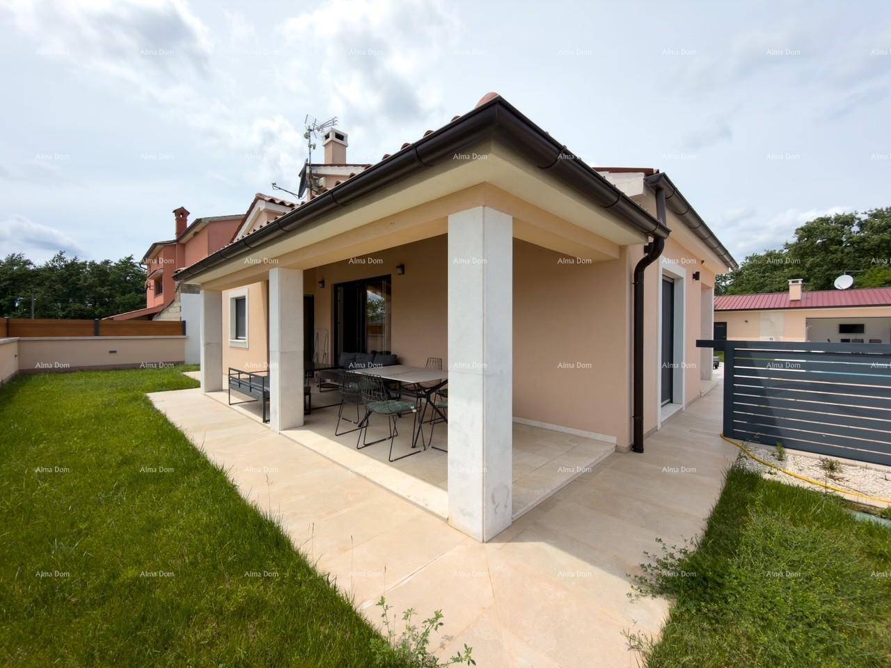 Außenansicht des Hauses mit großer überdachter Terrasse und gepflegtem Rasenbereich.