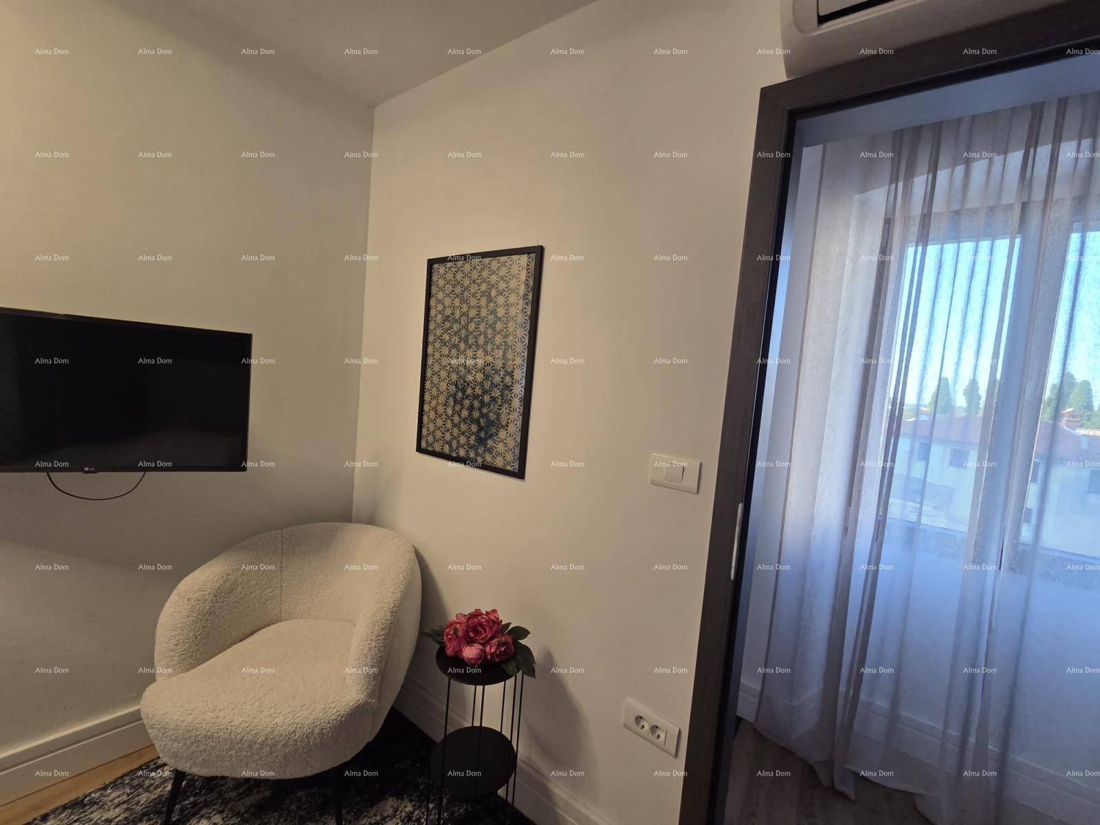 Gemütliche Ecke im Schlafzimmer mit Sessel, Wandfernseher und Vorhängen am Fenster.