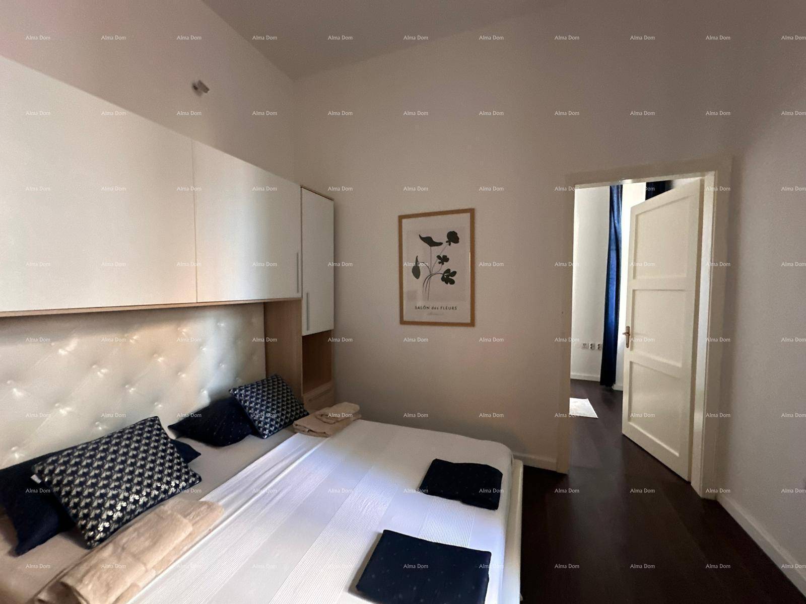 Gemütliches Schlafzimmer mit Doppelbett, Einbauschränken über dem Bett und dunklem Holzboden.