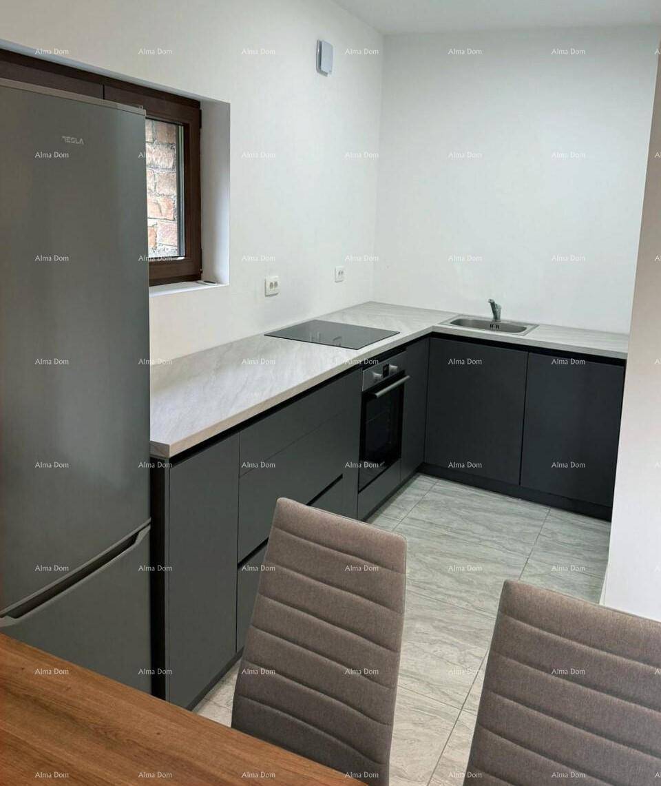 Moderne Einbauküche mit grauen Schränken, heller Arbeitsplatte und integriertem Kochfeld und Backofen.
