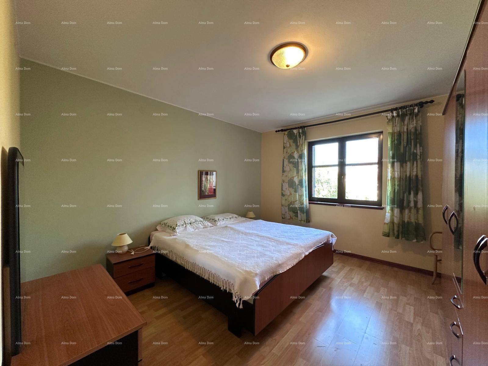 Geräumiges Schlafzimmer mit großem Fenster, Doppelbett und Holzmöbeln.