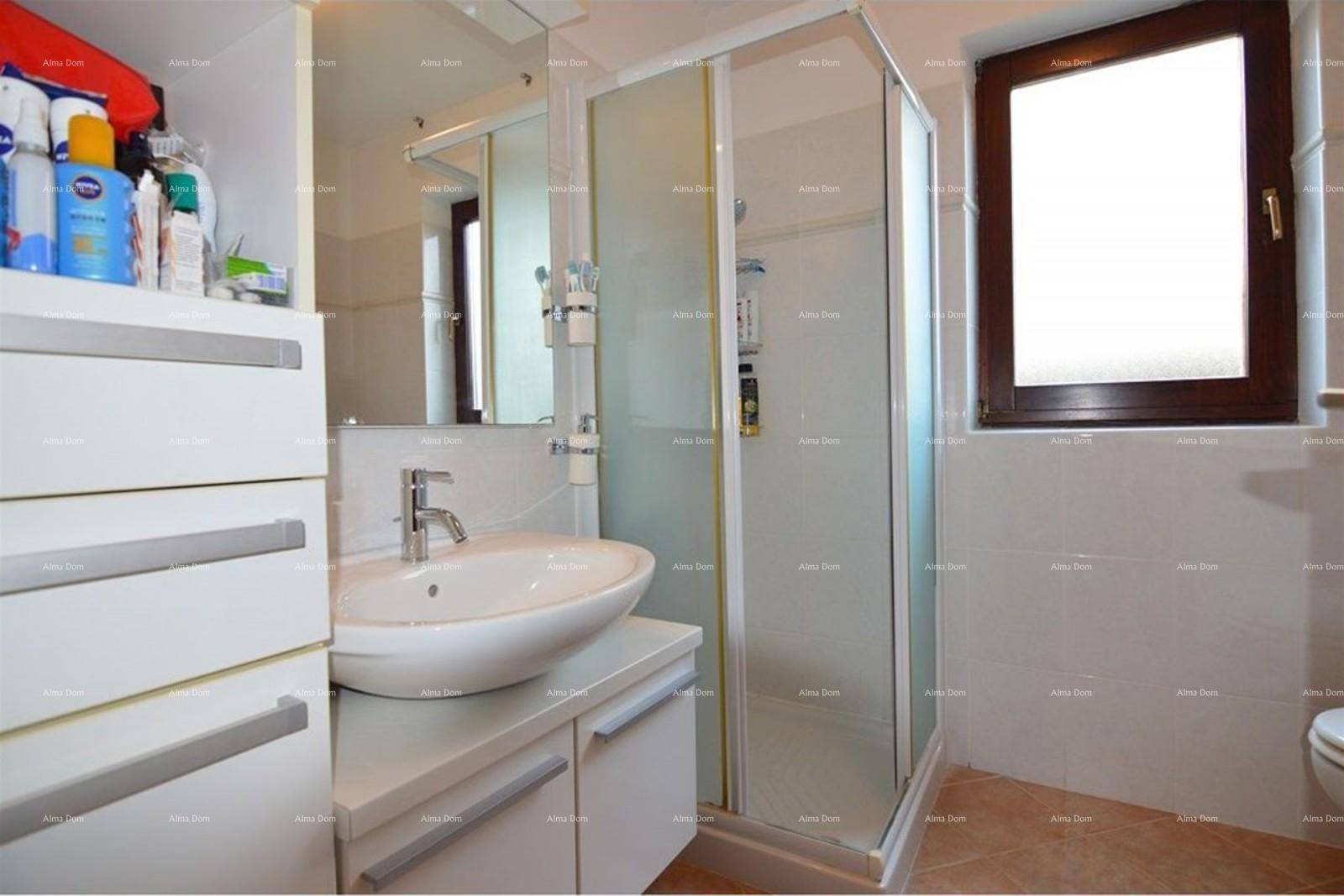 Modernes Badezimmer mit Duschkabine, Waschbecken und Fenster.