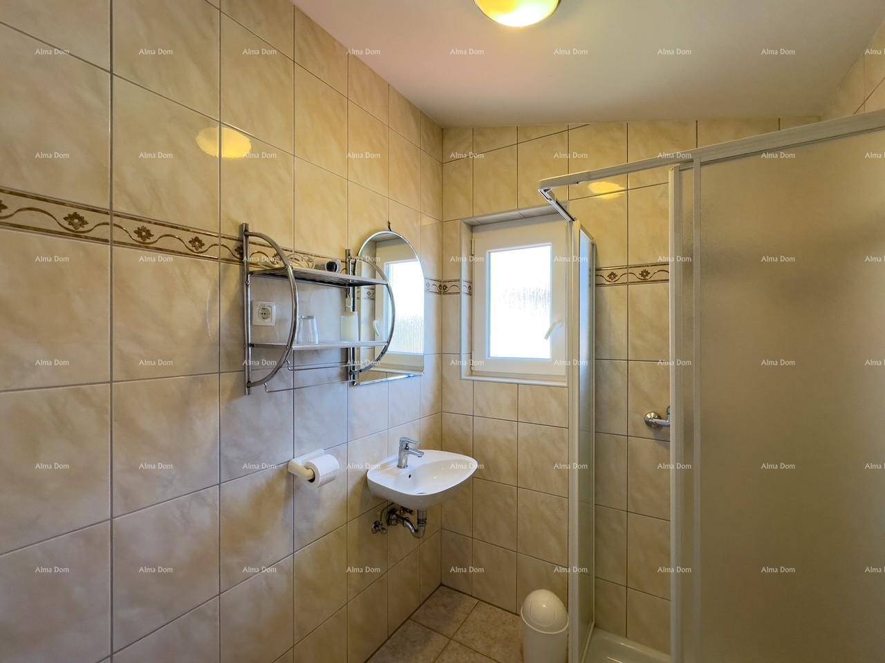 Helles Badezimmer mit Duschkabine, Waschbecken und Fenster für natürliche Belüftung.