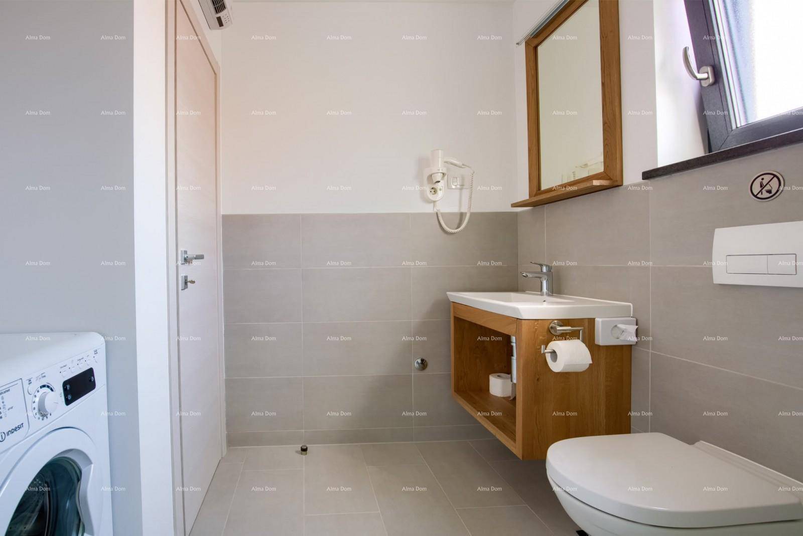 Modernes Badezimmer mit Toilette, Waschbeckenunterschrank aus Holz und Waschmaschine.