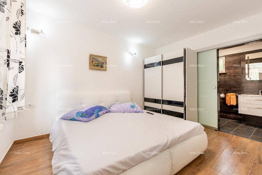 Helles Schlafzimmer mit Doppelbett und Schiebetür zu einem eleganten Badezimmer.