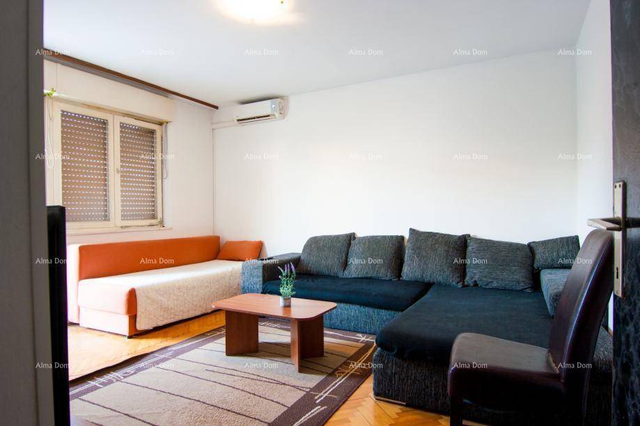 Wohnzimmer mit großem Sofa, Couchtisch und Klimaanlage an der Wand.