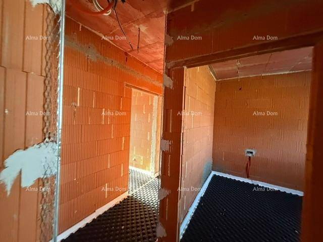 Unfertiger Flur mit Ziegelwänden und Fußbodenheizungsvorbereitung, bereit für den Ausbau.