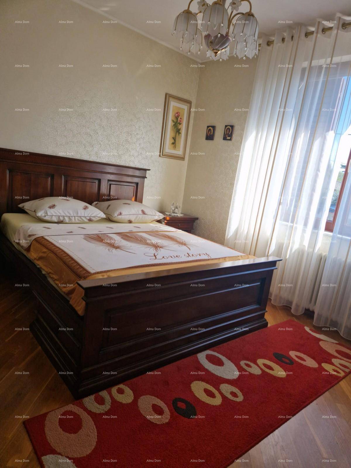 Gemütliches Schlafzimmer mit großem Holzbett, Parkettboden und viel Tageslicht.