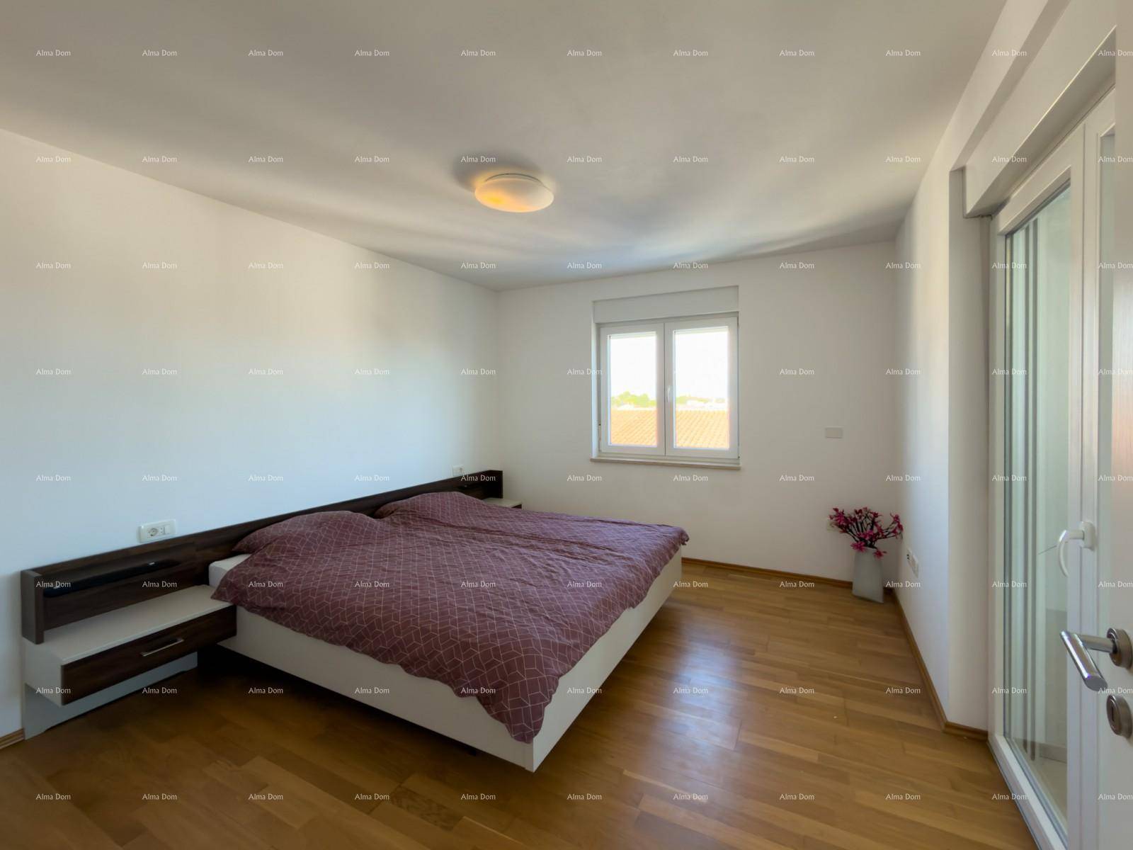 Helles Schlafzimmer mit Holzboden, Doppelbett und Zugang zu einem Balkon oder Wintergarten.