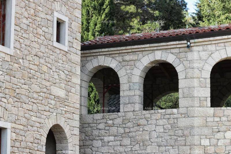 Detailansicht der Steinfassade mit Rundbögen und traditionellen Dachziegeln.