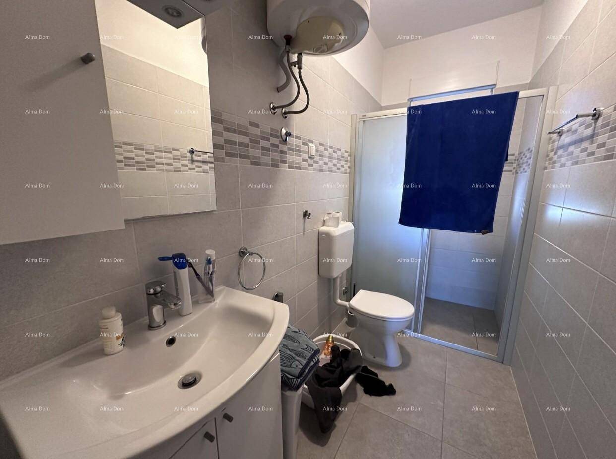 Modern gefliestes Badezimmer mit Waschbecken, Toilette und Duschkabine.