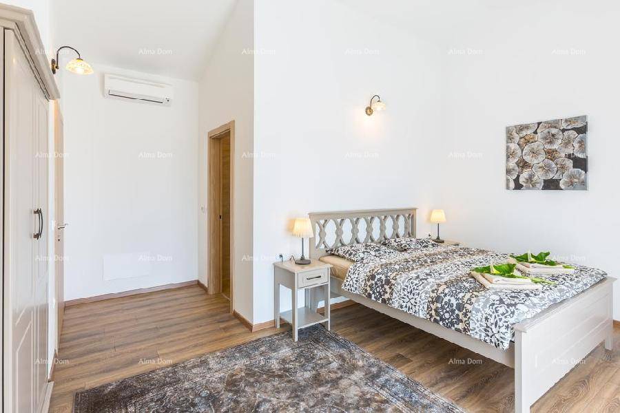 Schlafzimmer mit Klimaanlage, Doppelbett und Holzboden für angenehmen Komfort.