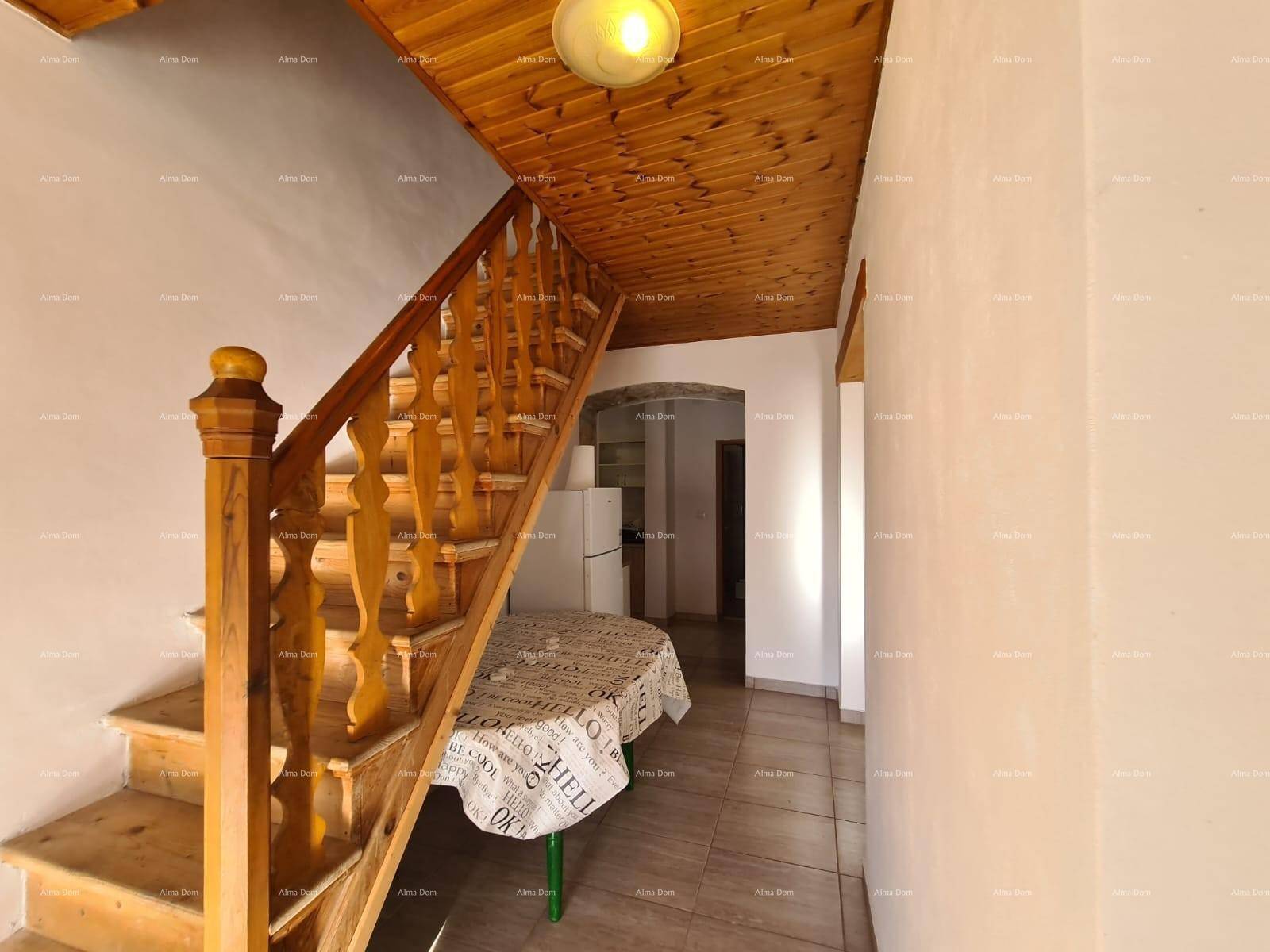 Eingangsbereich mit Holztreppe, Holzbalkendecke und Fliesenboden, der den rustikalen Charme unterstreicht.