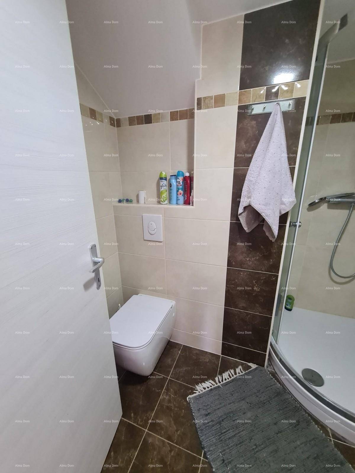 Funktionelles Badezimmer mit Toilette, Duschkabine und Fliesen in neutralen Farbtönen.