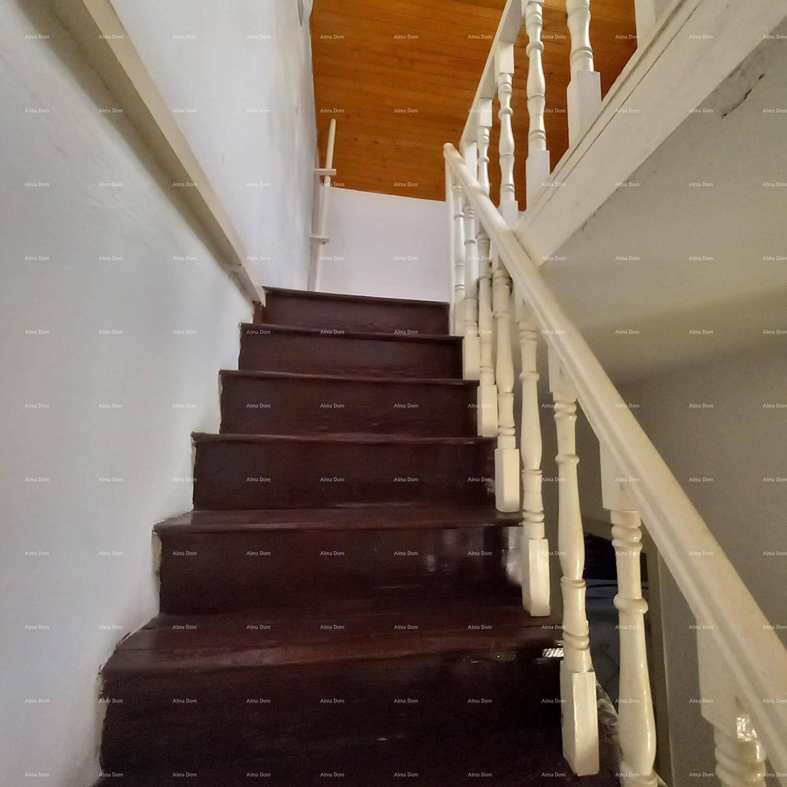 Holztreppe mit weißem Geländer führt in die oberen Etagen des Hauses.
