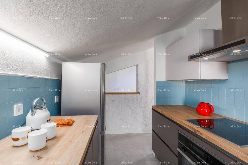 Moderne Küche mit blauen Fliesen, Holzarbeitsplatten und integrierten Edelstahlgeräten.