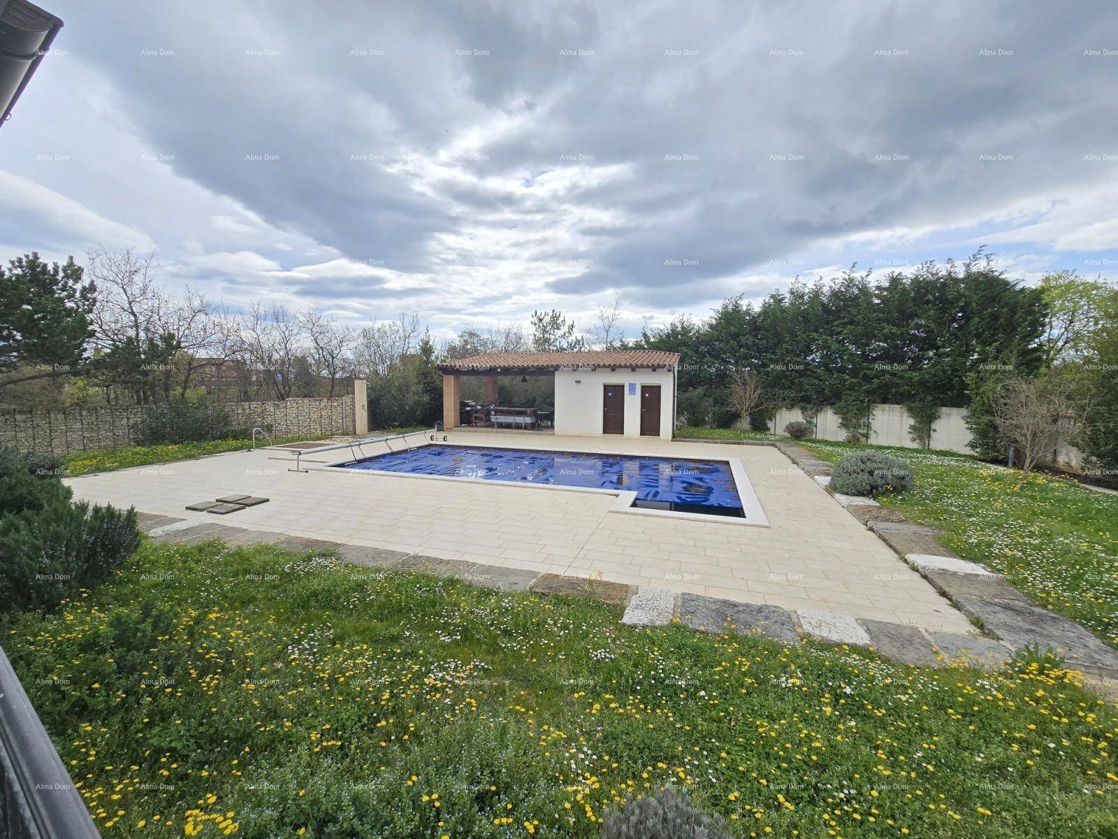 Weitläufiger Gartenbereich mit einem großen Pool und einer angrenzenden überdachten Terrasse.