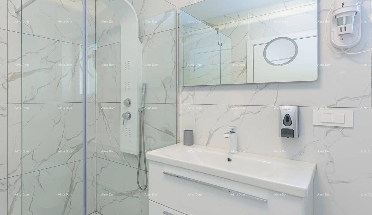 Modernes Badezimmer mit weißem Waschtisch, Spiegel und großer Duschkabine mit Marmorfliesen.
