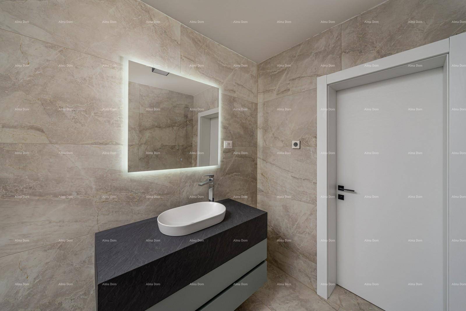Zeitgemäßes Badezimmer mit Fliesen, Waschtisch und beleuchtetem Spiegelschrank.