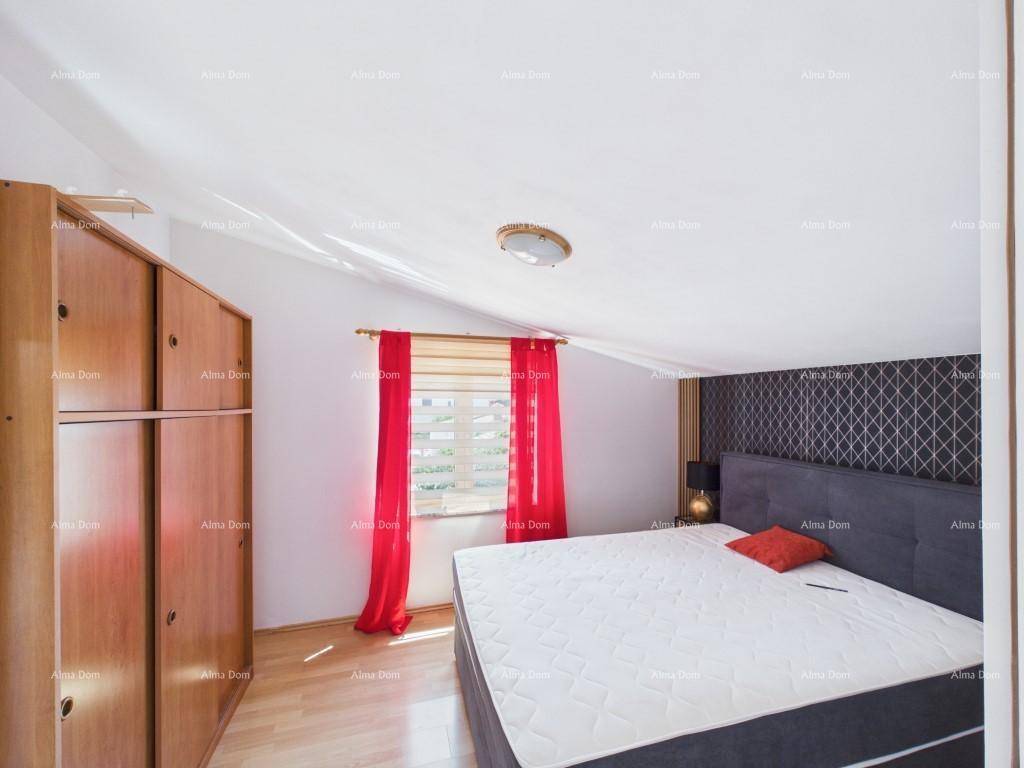 Gemütliches Schlafzimmer mit Holzboden, großem Bett und Kleiderschrank unter einer Dachschräge.
