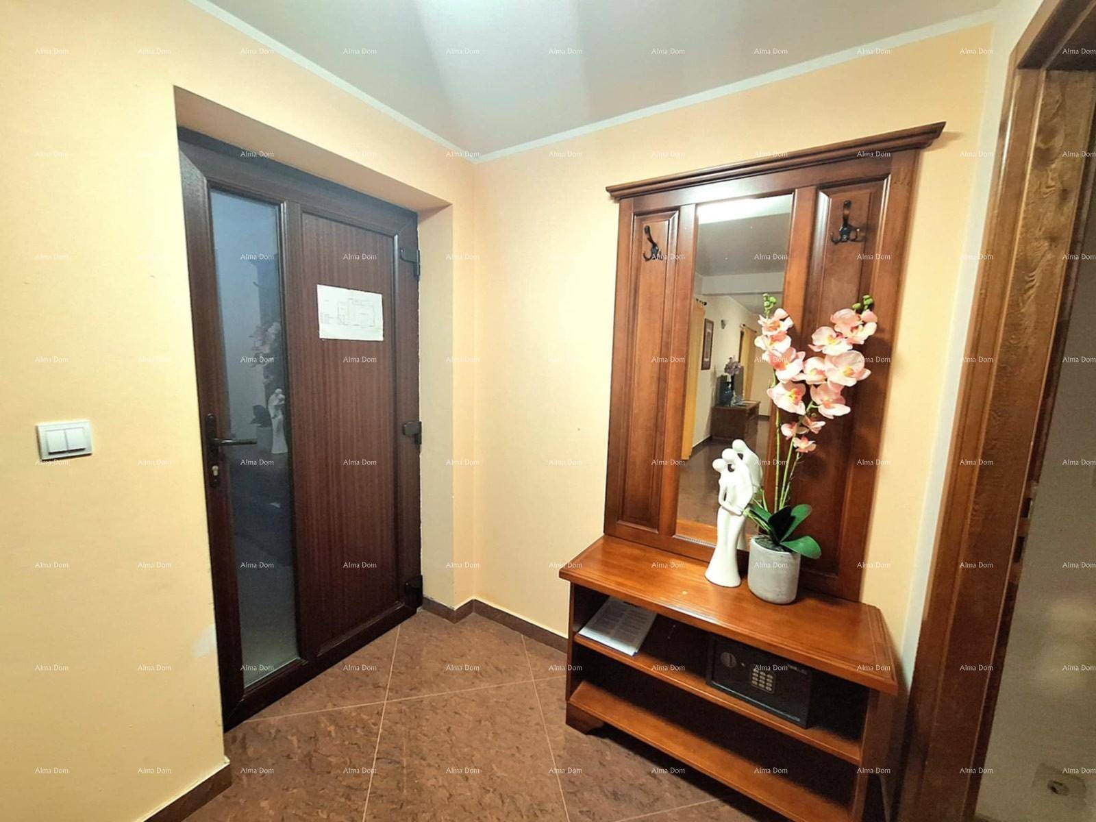 Eingangsbereich mit Garderobe, Spiegel und dekorativen Blumen, einladend gestaltet.
