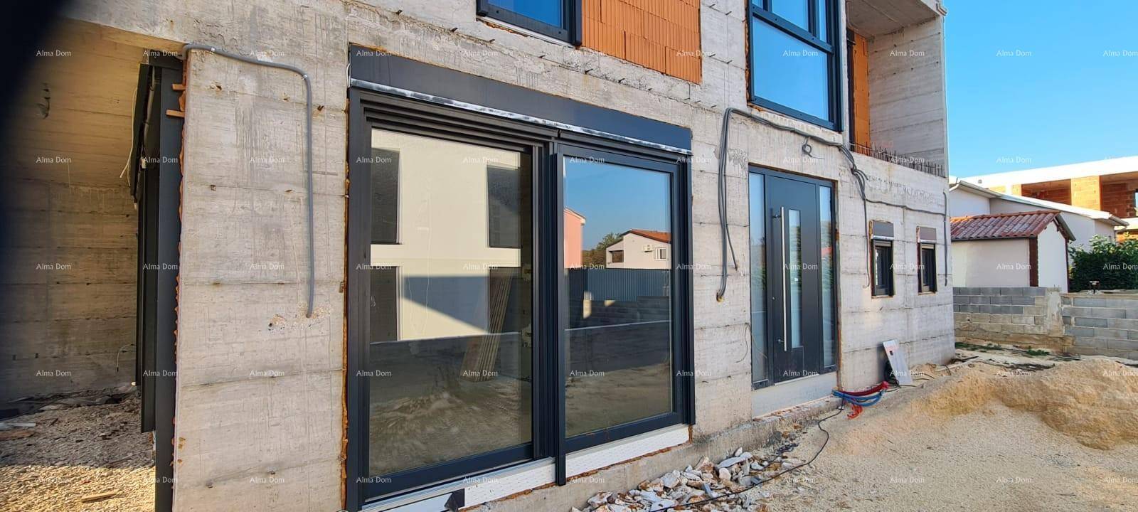 Nahaufnahme der modernen Fenster und der Eingangstür des im Bau befindlichen Gebäudes.