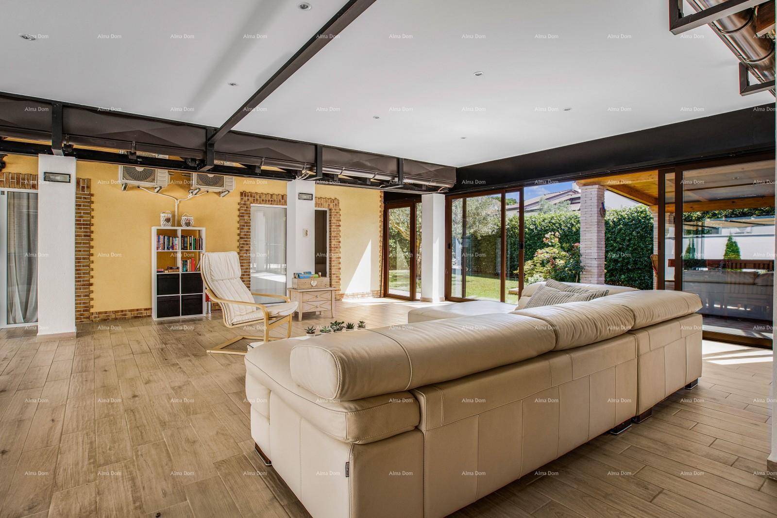 Heller Wohnbereich mit großem Sofa, Holzboden und Zugang zu einer Außenterrasse.