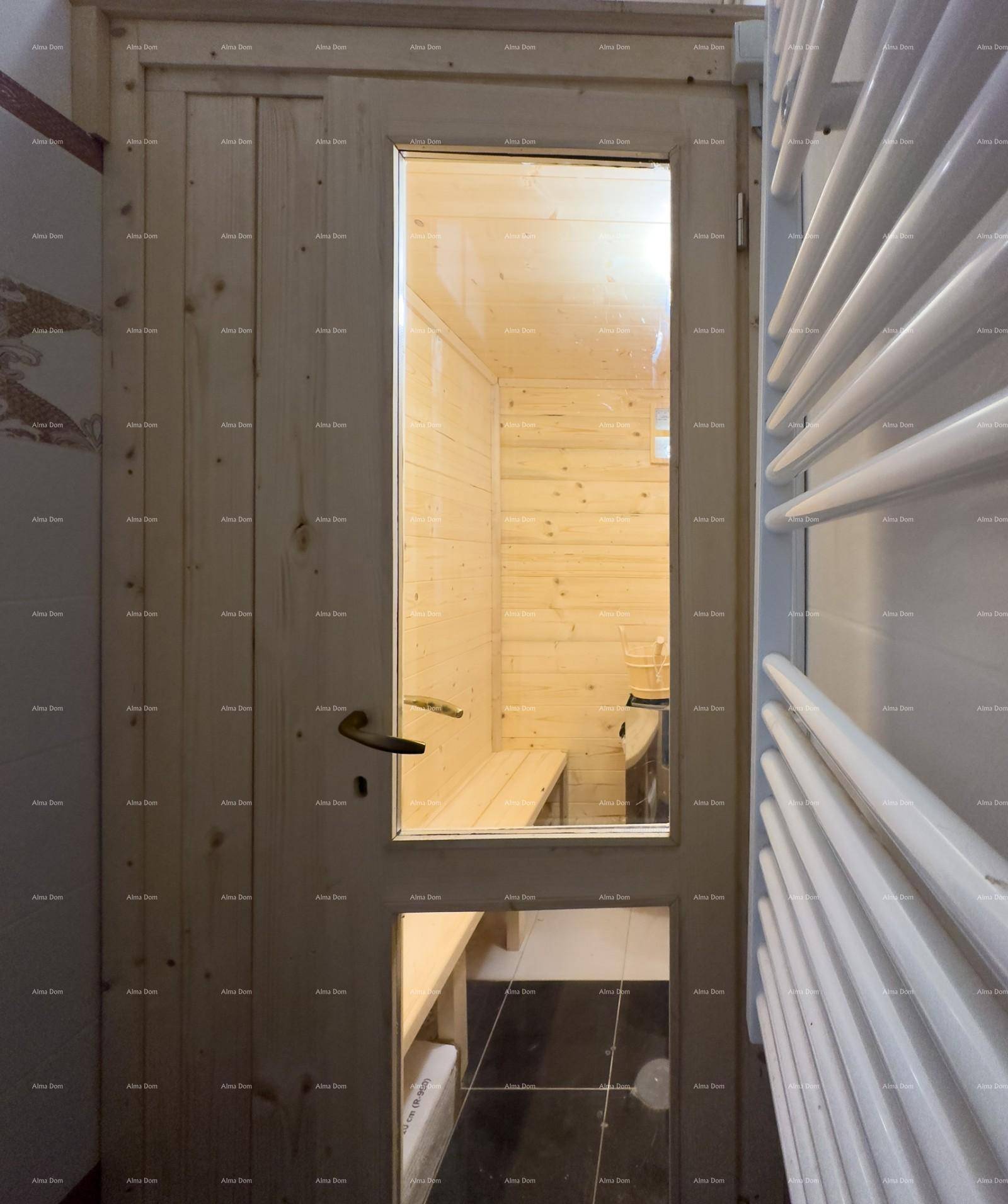 Innenansicht einer modernen Holzsauna mit bequemen Bänken, sichtbar durch eine Glastür.