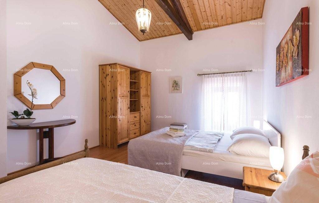 Schlafzimmer mit Holzbalkendecke, zwei Betten und großem Holzschrank.