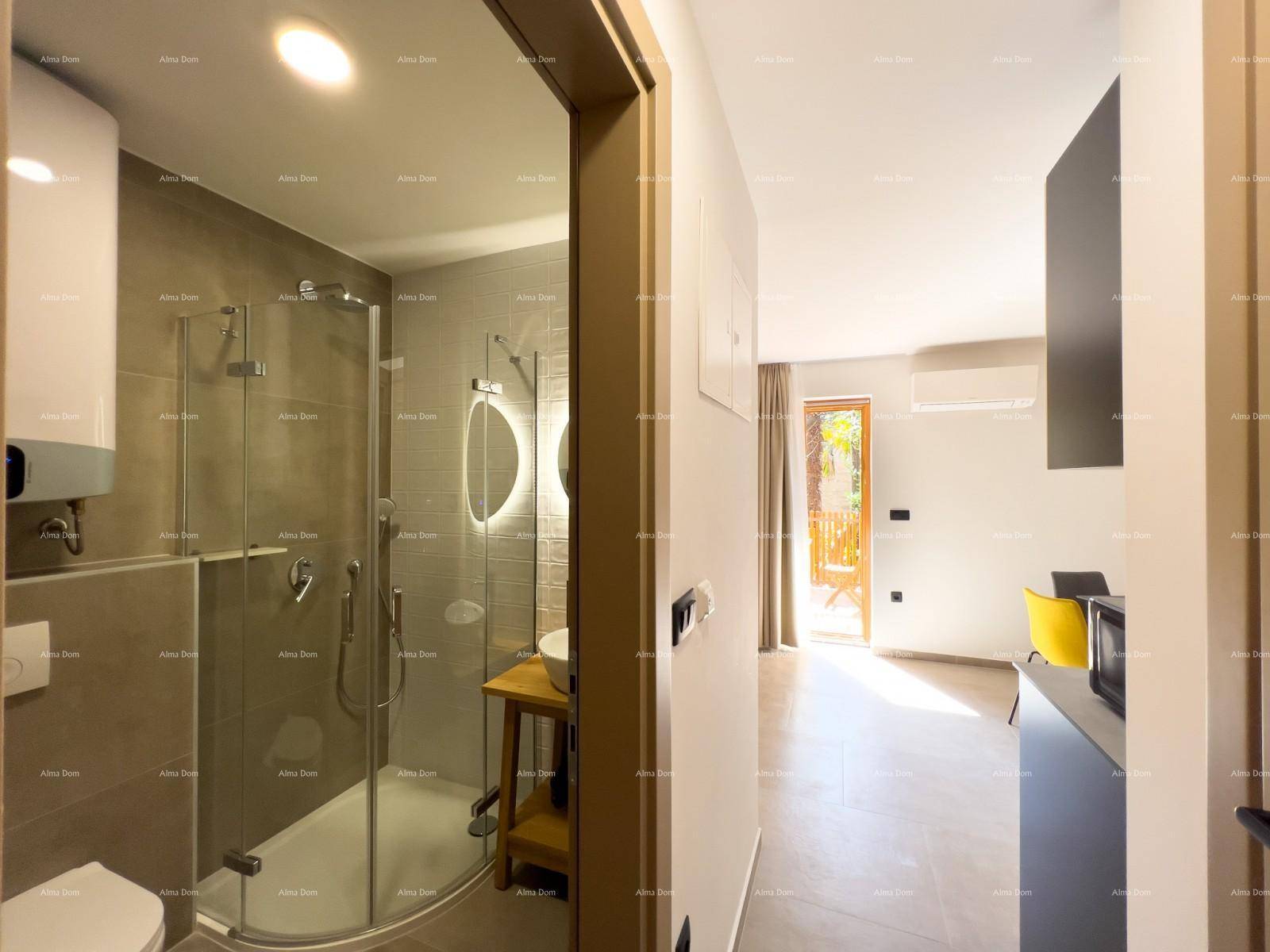 Blick vom modernen Badezimmer mit Dusche in den hellen Wohnbereich mit Balkonzugang.