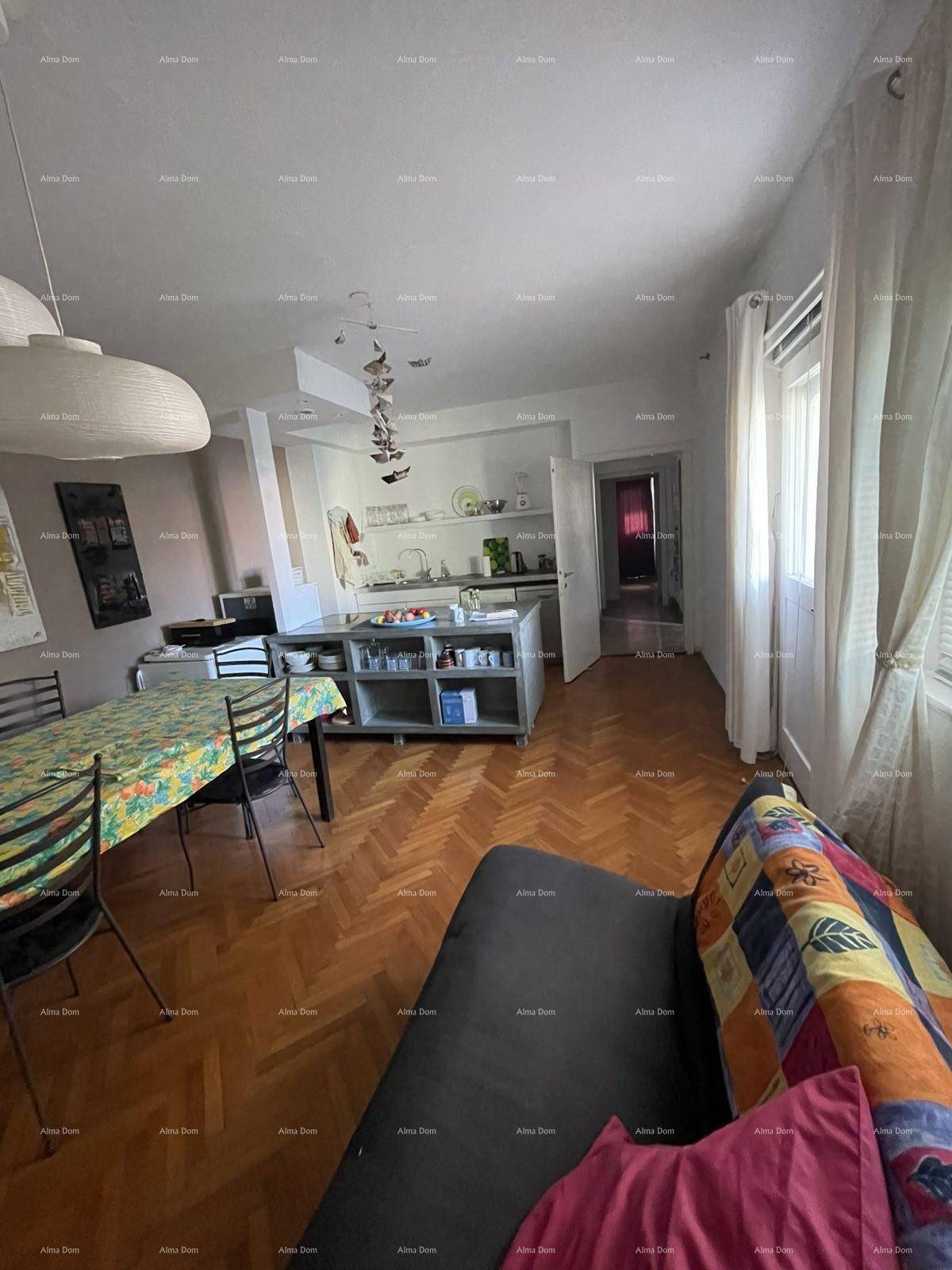 Geräumiger Wohn-Essbereich mit Holzboden, Sofa und Blick auf die offene Küche.