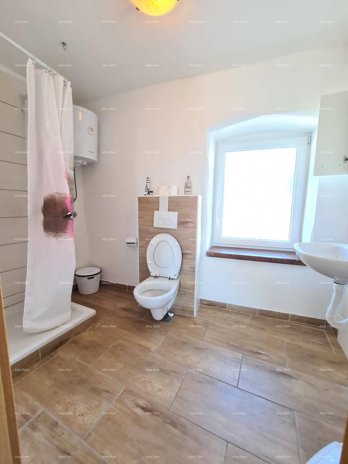 Helles Badezimmer mit Fenster, wandhängendem WC und Duschbereich.