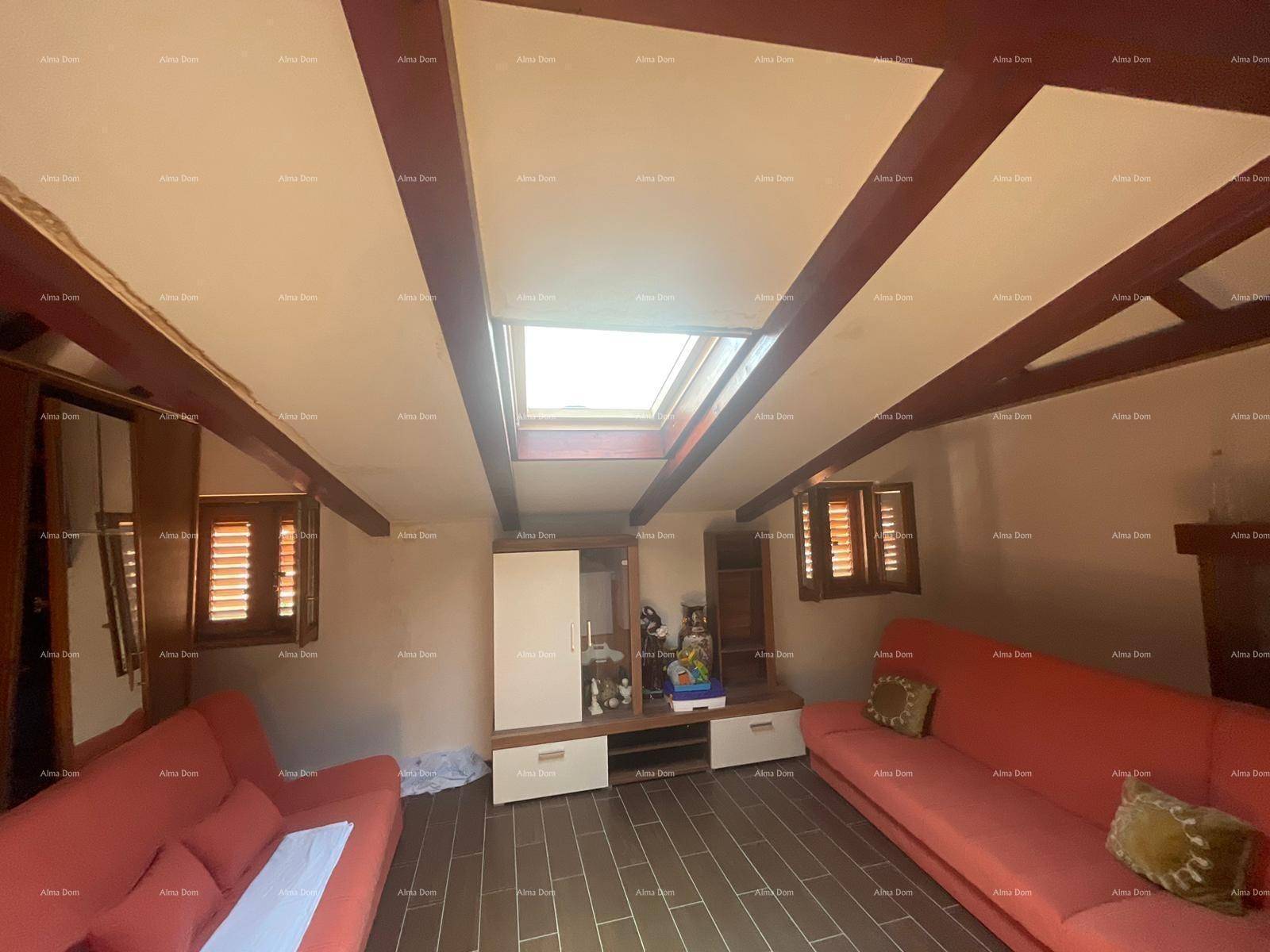 Gemütlicher Dachbodenraum mit sichtbaren Holzbalken, Dachfenster und roten Sofas.