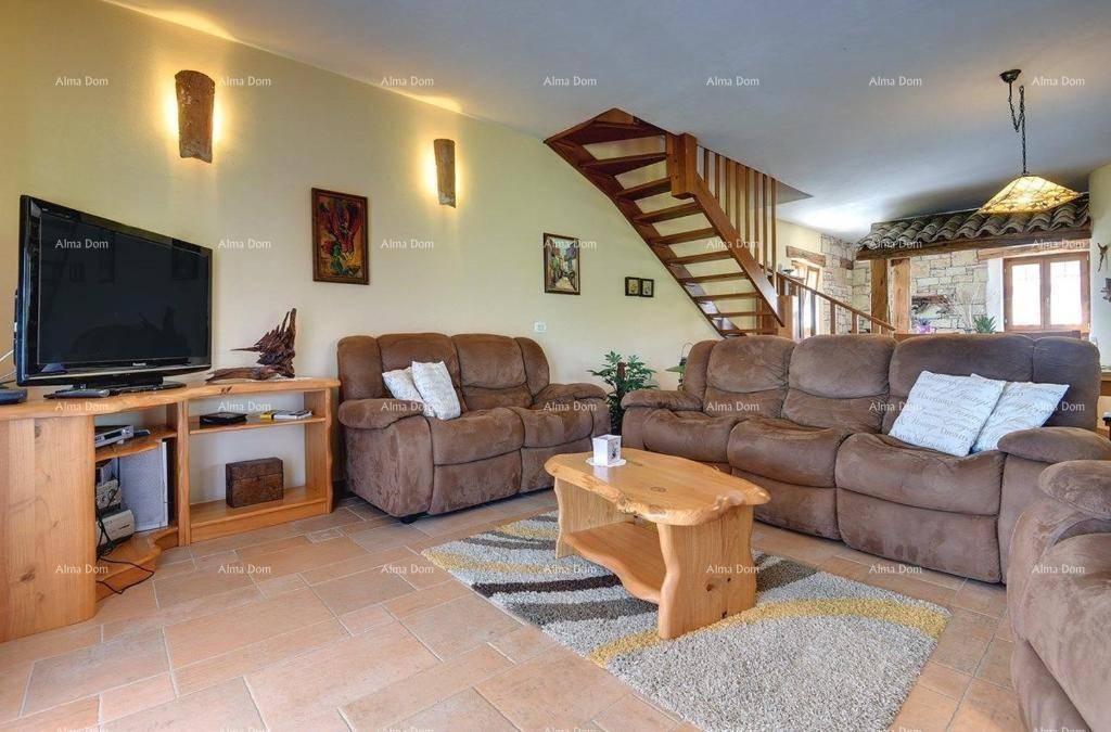 Gemütliches Wohnzimmer mit bequemen Sofas, Fernseher und rustikalem Holztisch, verbunden mit der Treppe.