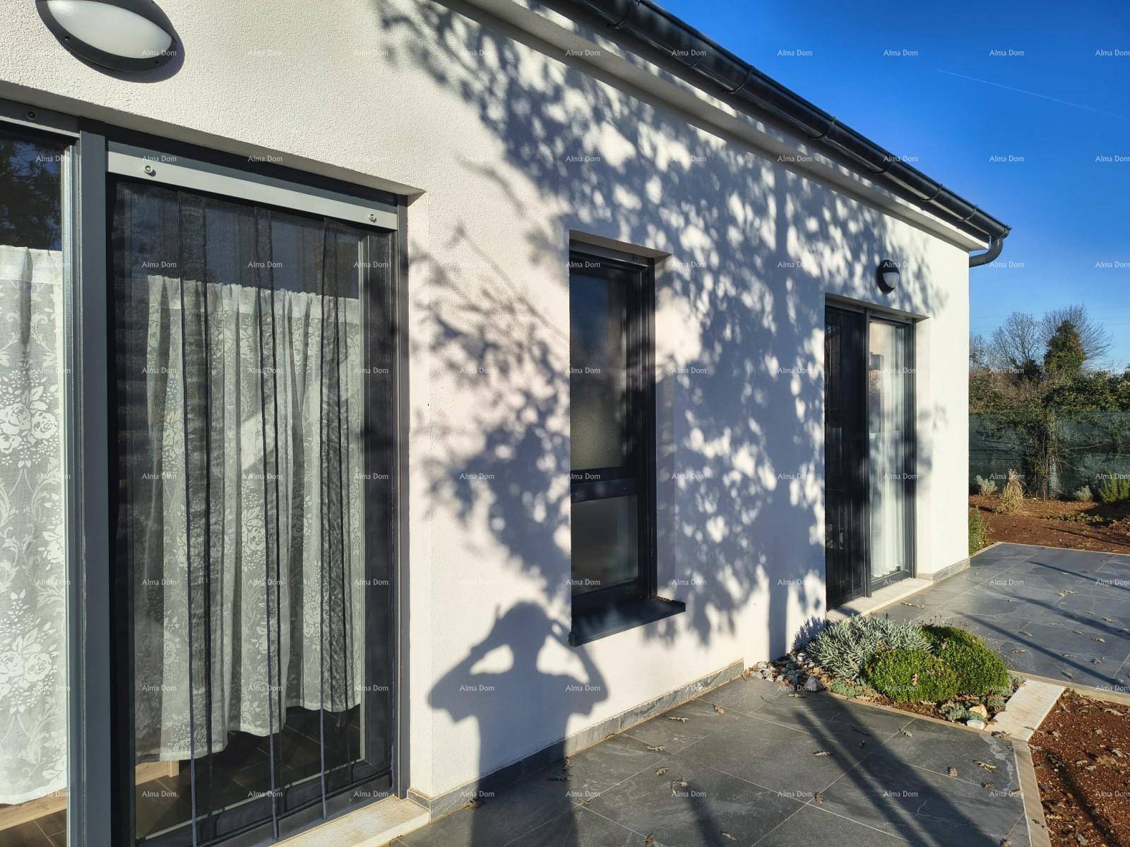 Nahaufnahme der modernen Hausfassade mit großen Fenstern und Vorhängen.