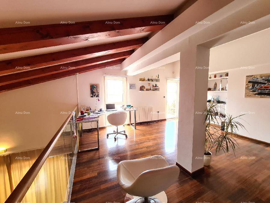 Offene Galerie, die als Arbeitsbereich genutzt wird, mit Holzbalken und Blick auf den Wohnbereich.