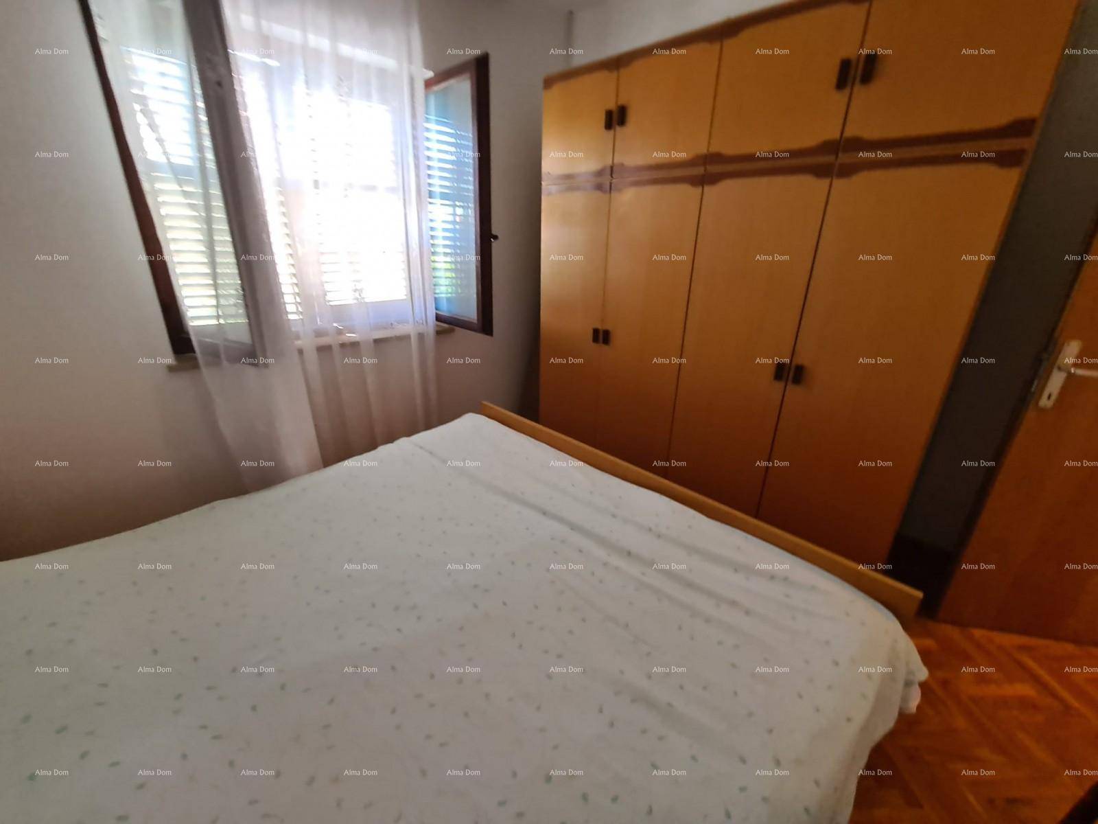 Schlafzimmer mit Holzboden, einem Doppelbett und einem großen Holzschrank, bietet viel Stauraum.